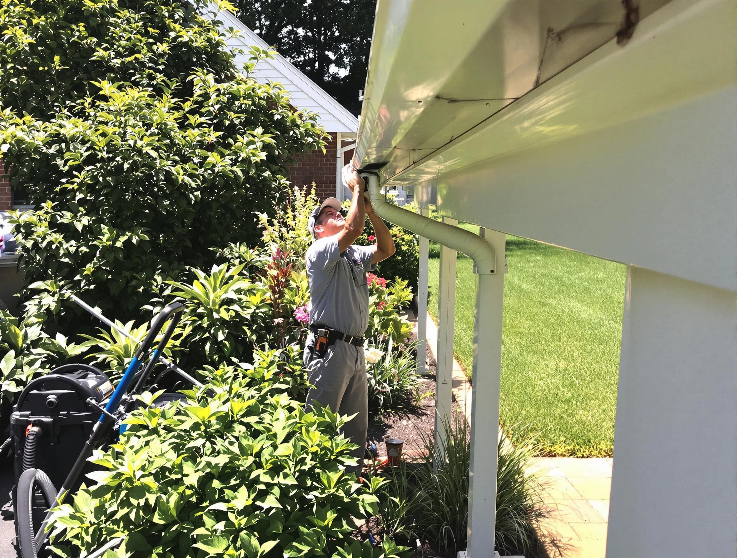 Technician flushing a blockage from a downspout in Mentor, OH